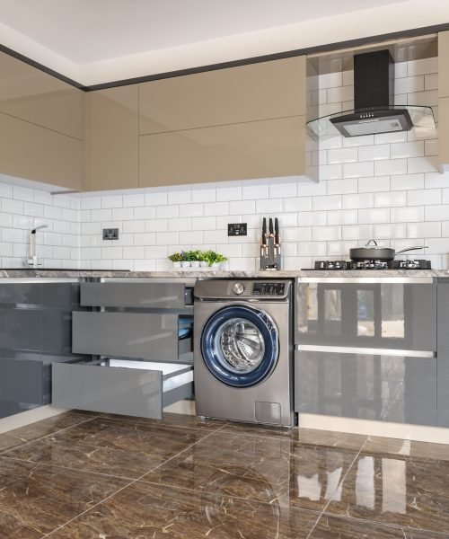 Spacious luxury well designed modern grey, beige and white kitchen with marble tiles floor. some lockers and door of electric oven are open